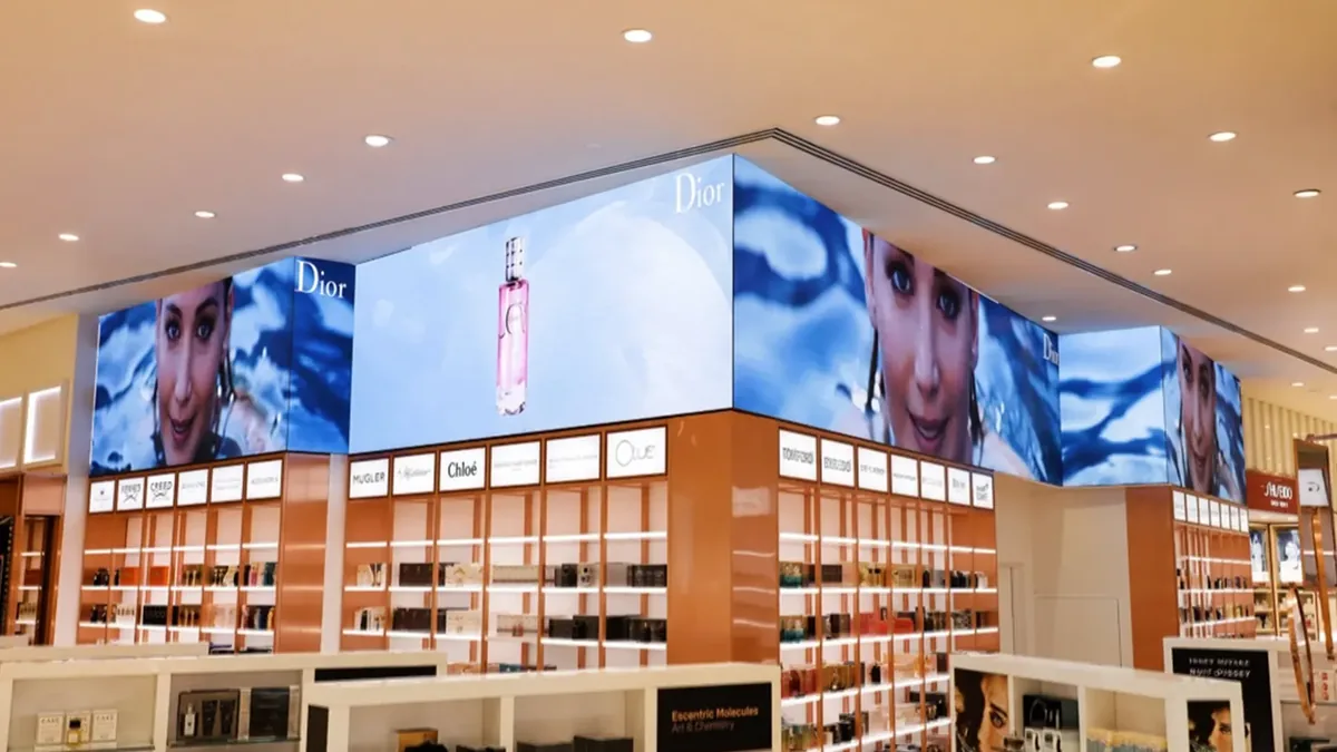 Indoor LED video wall installed above a cosmetics retail area with corner display surfaces