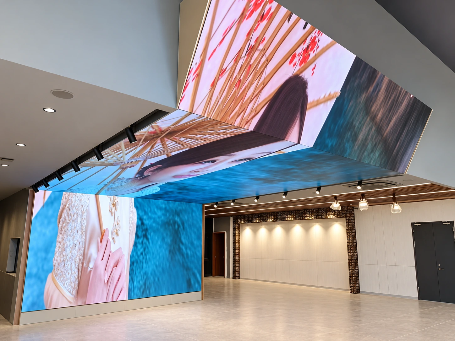 Retouched indoor LED installation with a connected wall, overhead screen and vertical return displaying blue and pink imagery